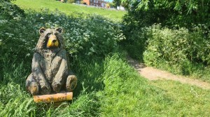 A bear next to a hedge